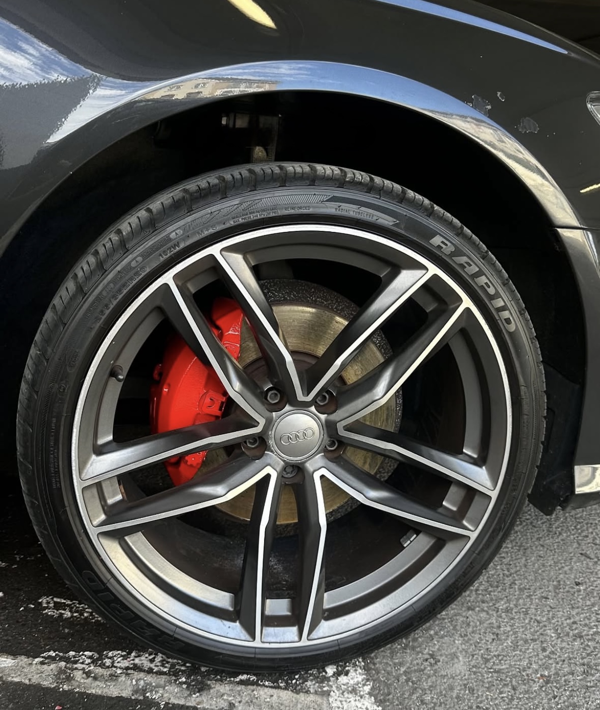 Audi wheel with professionally painted red brake caliper after painting